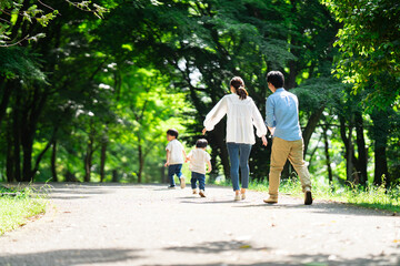 新緑の公園を散歩する家族	
