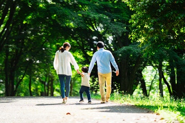 手を繋いで歩く家族の後ろ姿