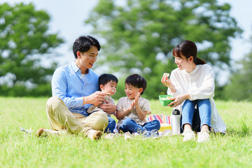 Fototapeta premium 公園でピクニックする四人家族 