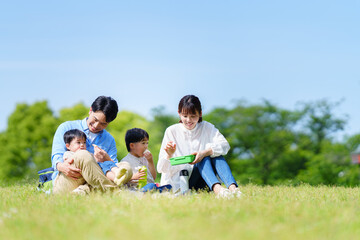 公園でピクニックする四人家族	
