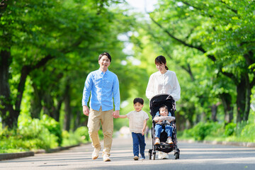  並木道を歩く四人家族