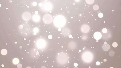 Elegant white bokeh particles floating in a soft diffused light background for a magical or dreamy effect creating a festive or celebratory mood.