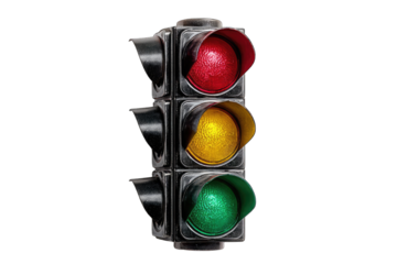 A classic three-light traffic signal, red, yellow, and green, set against a stark black background.  The lights are illuminated, and the casing shows signs of age or weathering