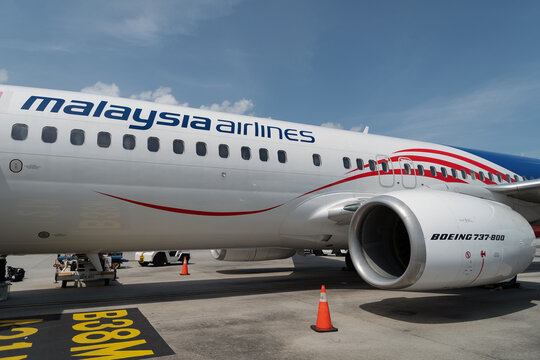 Langkawi, Malaysia - September 10, 2024: Malaysia Airlines Boeing 737 (B737-800) parked on tarmac after arrival at Langkawi Airport, showing mid fuselage section with wing root and CFM56 engine.