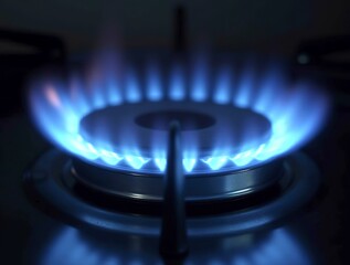 Bright flame on a stove burner illuminating a darkened kitchen, highlighting the cooking surface at night - symbolizing warmth, home cooking, and culinary activity after hours.