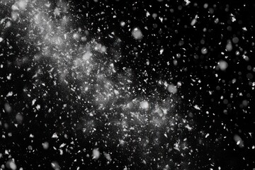 Obraz premium Close-up view of snowflakes falling densely against a dark night sky, creating a sense of coldness and winter atmosphere