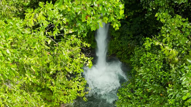 Beautiful waterfall in green forest, aerial view. Tropical Tuasan Falls in mountain jungle. waterfall in the tropical forest. Camiguin, Philippines, Mindanao