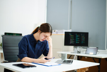 Frustrated female programmer feeling overwhelmed by code and deadlines at her desk