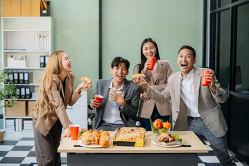 Young Asian Professionals Celebrating with Pizza and Drinks in a Modern Office Setting