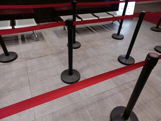 Red standing barrier queue lines installed to maintain order in the queue