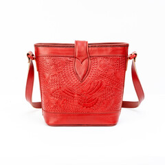 Beautiful red leather shoulder bag with embossed decoration for women isolated on white background,...