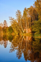 Tranquil Reflections: House and Trees Mirrored in River