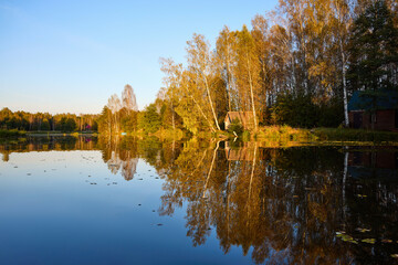 Tranquil Reflections: House and Trees Mirrored in River