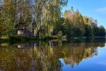 Tranquil Reflections: House and Trees Mirrored in River