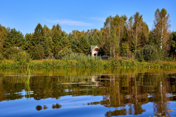 Tranquil Reflections: House and Trees Mirrored in River