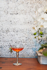Orange Cocktail in Coupe Glass Beside White Orchids