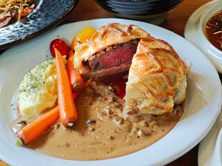 Beef Wellington, fillet steak coated , wrapped in puff pastry served with grilled vegetables