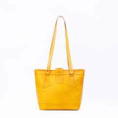 Beautiful yellow leather shoulder bag with embossed decoration for women isolated on white...