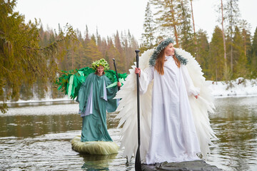 Girls in a white and green dress celebrate the meeting of winter and spring by the lake during a...
