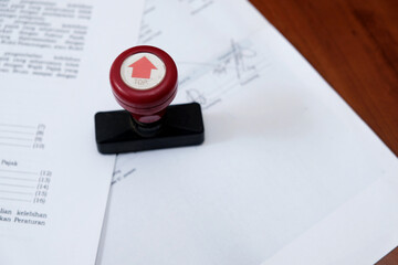 A stamp on a document approved certified contract, law and paperwork permit in the wooden table. 