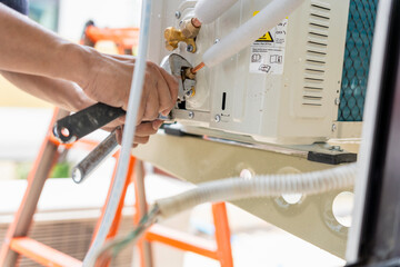 Close Up of Technician Installation Outdoor Air Conditioning Unit with Wrench, Repairman fix air...