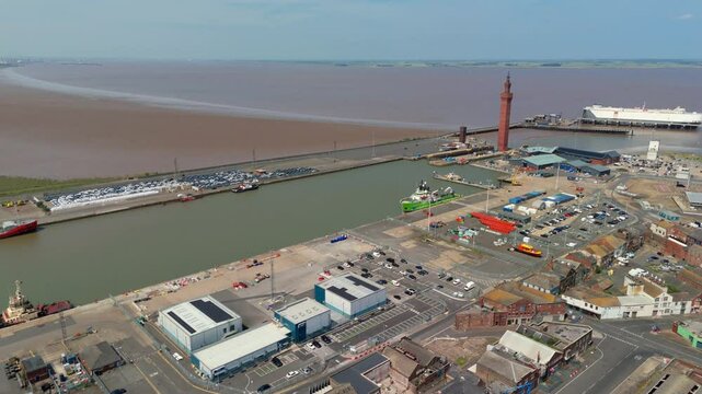 Aerial drone perspective of Clock tower and port harbour area of Grimsby England. Shipping canals and cargo ships, yachts, ferrys and fishing boats, industrial development area.