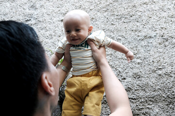 A Southeast asian father playing with baby boy in the home garden, doing everything together. Happy family 