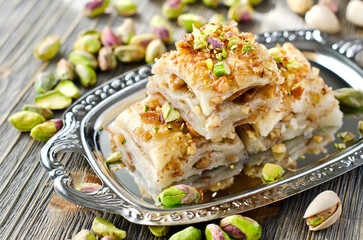Turkish pistachio pastry dessert  baklava with green pistachios on a silver tray