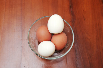 Bowl containing chicken boiled egg  on the kitchen table, prepares breakfast at home, health care and food concept. Copy space