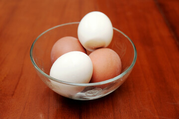 Bowl containing chicken boiled egg  on the kitchen table, prepares breakfast at home, health care and food concept. Copy space