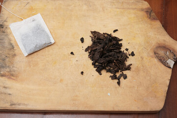 Tea bags and a bunch of loose tea in the wooden board. A quick and convenient way to brew tea.
