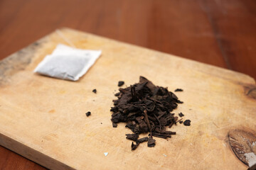 Tea bags and a bunch of loose tea in the wooden board. A quick and convenient way to brew tea.