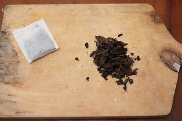 Tea bags and a bunch of loose tea in the wooden board. A quick and convenient way to brew tea.