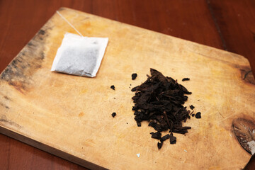 Tea bags and a bunch of loose tea in the wooden board. A quick and convenient way to brew tea.