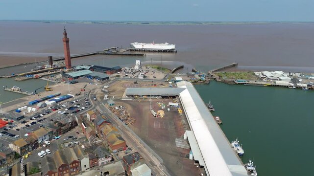 Aerial drone perspective of Clock tower and port harbour area of Grimsby England. Shipping canals and cargo ships, yachts, ferrys and fishing boats, industrial development area.