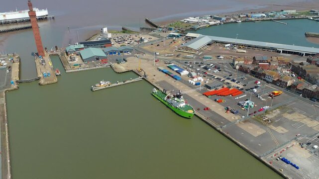 Aerial drone perspective of Clock tower and port harbour area of Grimsby England. Shipping canals and cargo ships, yachts, ferrys and fishing boats, industrial development area.