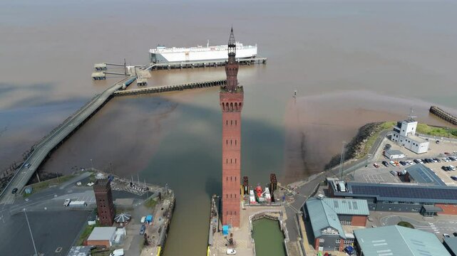 Aerial drone perspective of Clock tower and port harbour area of Grimsby England. Shipping canals and cargo ships, yachts, ferrys and fishing boats, industrial development area.