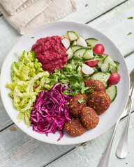 Falafel and beetroot bowl with red cabbage, radishes, salad and cucumber