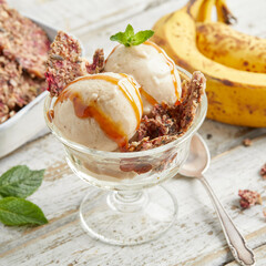 Banana nice cream scoops with caramel sauce and biscuit