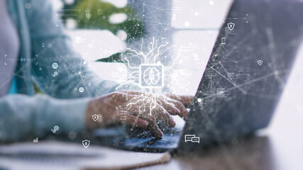 Hands typing on laptop with AI digital interface overlay, symbolizing artificial intelligence...