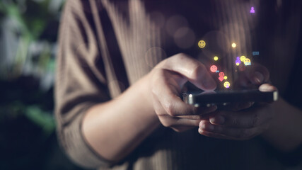 Close-up of hands holding smartphone with floating social media icons, symbolizing digital interaction, real-time communication, and online user engagement for modern technology and lifestyle themes.