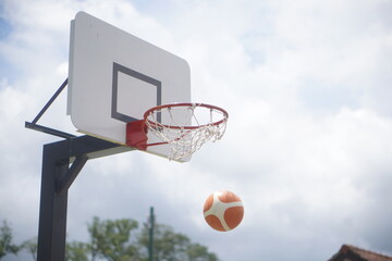外でストリートバスケット。バスケットゴールにシュートしたボール。