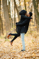 Loving black couple walking in park and enjoying autumn day