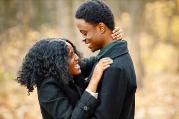 Loving black couple walking in park and enjoying autumn day