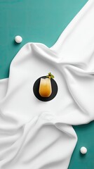 Yellow Cocktail in Tumbler on White Fabric with Teal Background