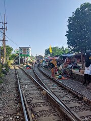 Obraz premium Extreme Market in Surabaya where vendors sell along both sides of active railway tracks at Pasar Dupak Magersari, capturing dense trade activity and a unique urban environment in East Java