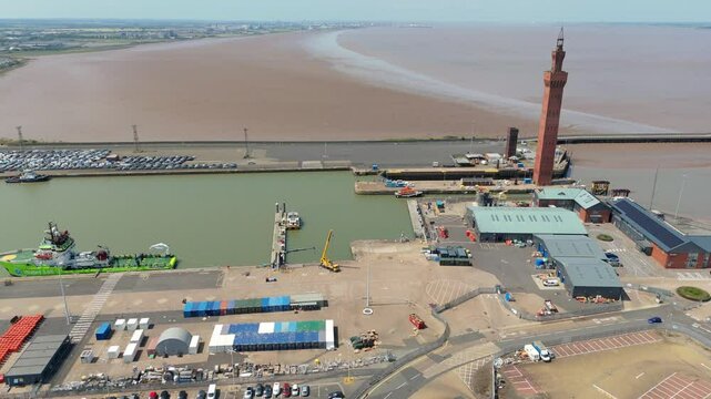 Aerial drone perspective of Clock tower and port harbour area of Grimsby England. Shipping canals and cargo ships, yachts, ferrys and fishing boats, industrial development area.