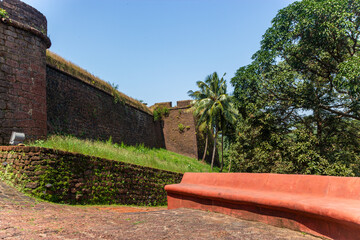 Red bench by ancient fort walls in Goa