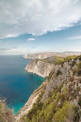 Discover stunning views of dramatic cliffs meeting crystal-clear waters on a coastal adventure. This pristine landscape beckons explorers seeking tranquility and natural beauty amidst lush greenery
