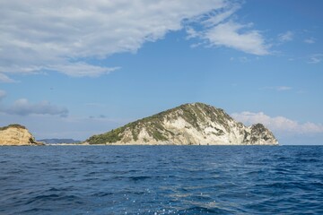 Sailing towards secluded islands, a group of adventurous travelers enjoys the serene ocean breeze and stunning views under a bright summer sky. Perfect for nature lovers and explorers